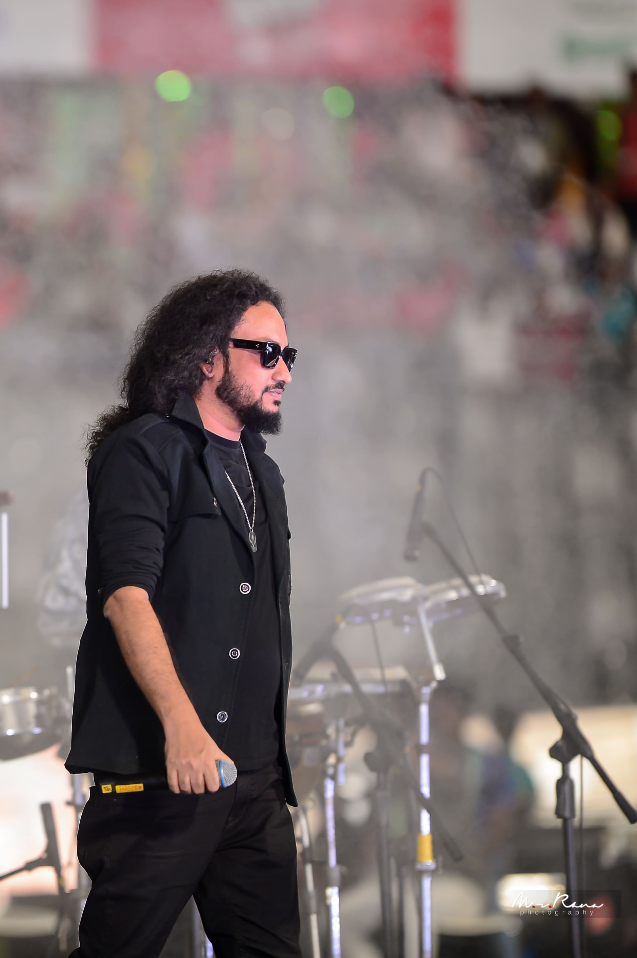 Muttaque Hasib in profile on stage holding a microphone